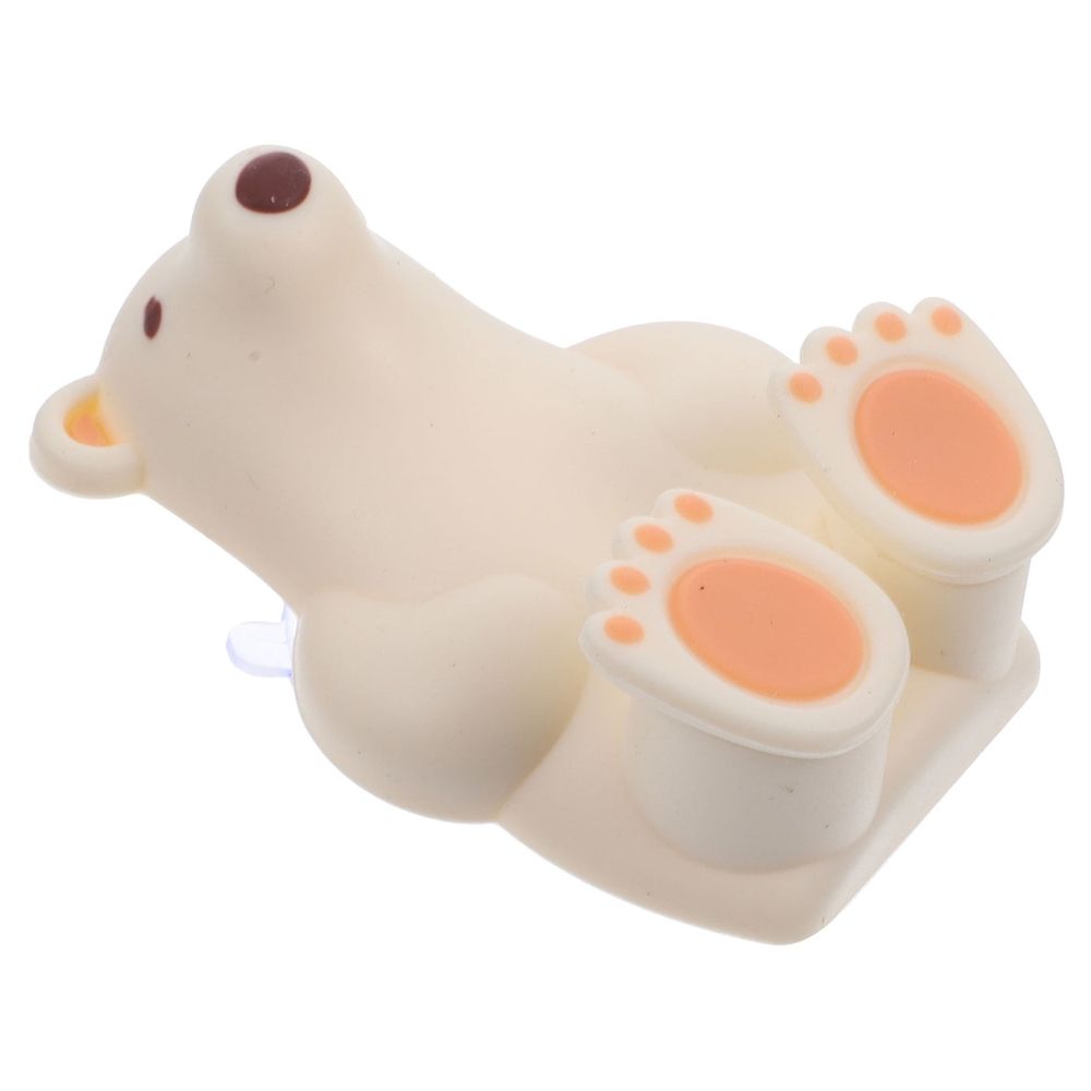 Beige silicone suction cup toothbrush holder for babies and kids, designed for bathroom use, by Everything Baby.
