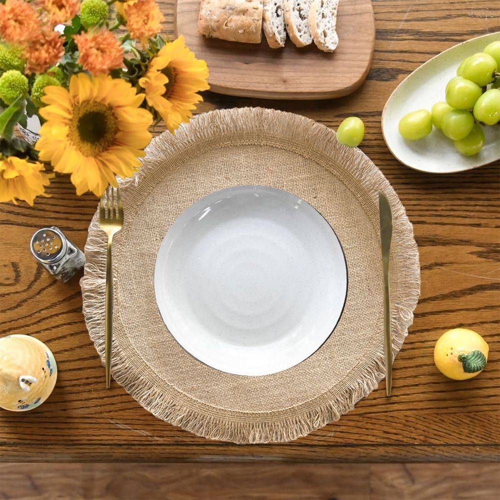 Round jute placemat with tassel fringe, natural linen material, heat resistant, for bowls and dishes, easy to clean with damp cloth.