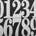 White mailbox address numbers set by Everything Baby, easy to install for a clean, modern look in home or mailbox decor.