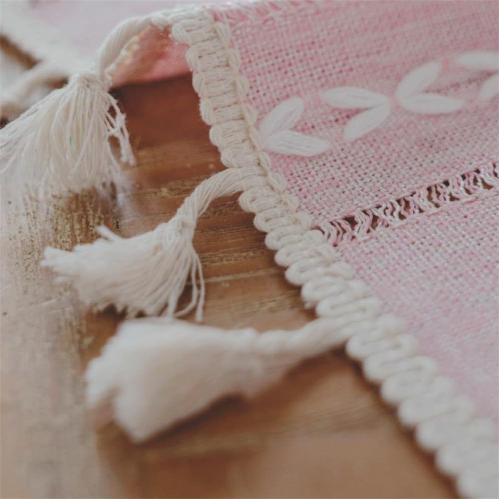 Pink boho-style rectangular tablecloth with tassel stripe pattern for dresser or bedside table, made of woven polyester fabric.