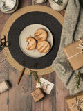 Set of four 15-inch black woven placemats with paper edges, washable and heat-resistant, ideal for indoor and outdoor parties.