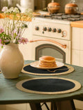 Set of four 15-inch black woven placemats with wide paper edges, washable and heat resistant, suitable for indoor and outdoor use.