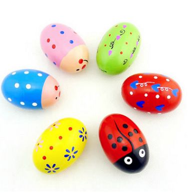 Six wooden percussion shakers shaped like Easter eggs with toys inside, ideal for toddler Easter basket and Montessori pretend play.