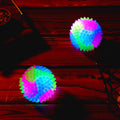 Two light-up spiky dog tennis balls with LED glow and squeaker, designed for fetch and nighttime play.