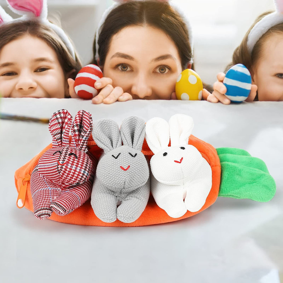 Three plush Easter bunnies in a carrot-shaped pouch, soft stuffed animals with zip-up closure, for baby and kids gifting.