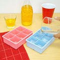 Pink and blue square ice cube trays by Everything Baby, used for making large ice cubes for drinks in a colorful kitchen setting.