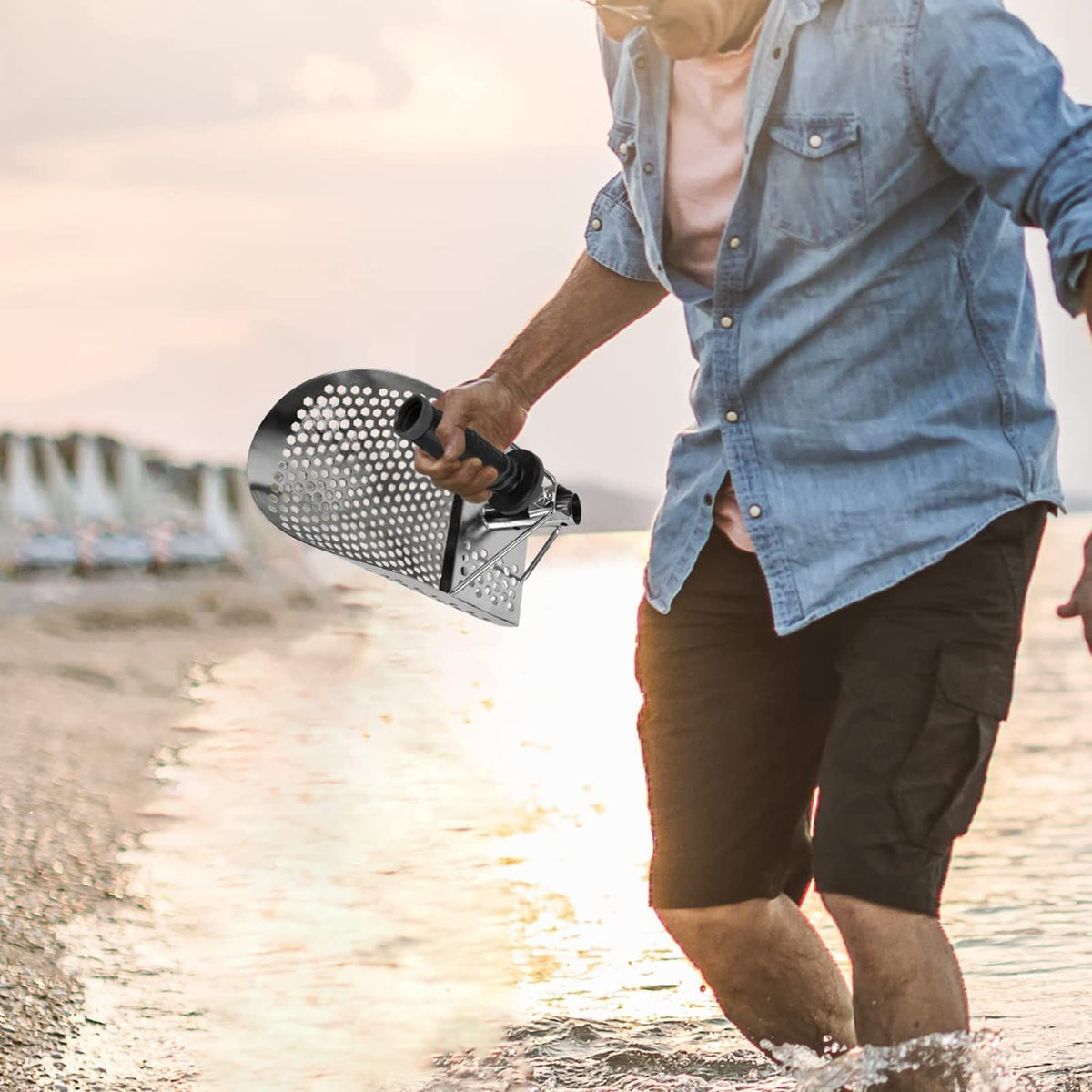 Stainless steel beach sand scoop with extra handle for metal detecting, designed for outdoor water play and sand exploration.