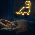 Colorful dinosaur neon LED sign light, perfect for kids' room decor and birthday parties, from Everything Baby.