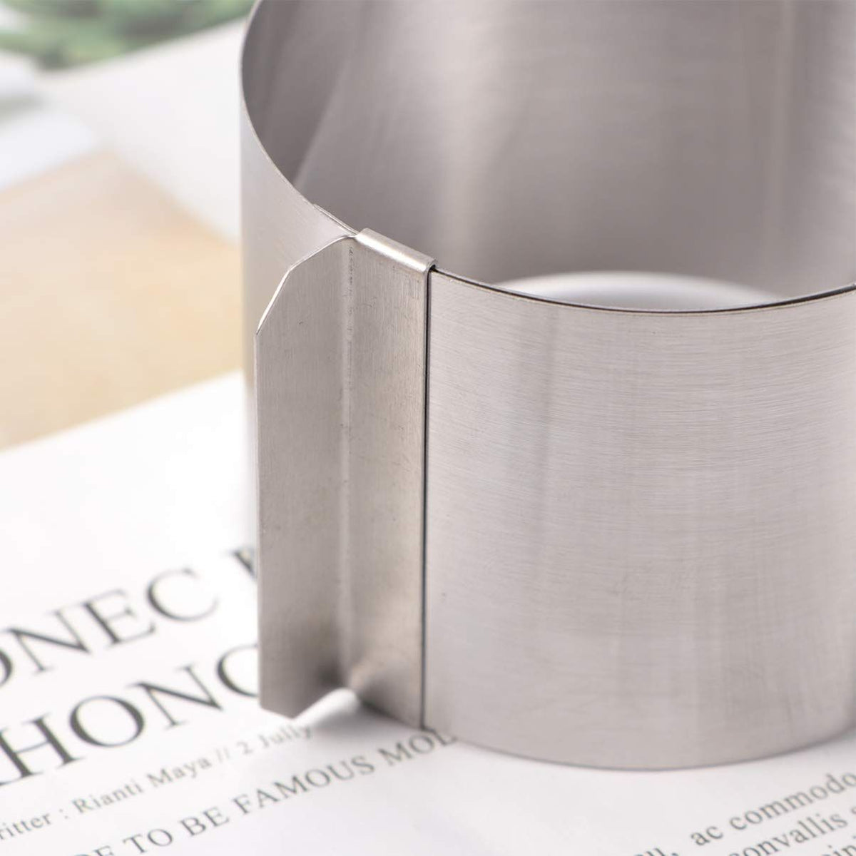 Adjustable stainless steel cake mold ring for baking, showing a round, retractable mousse cake mold with a smooth finish.