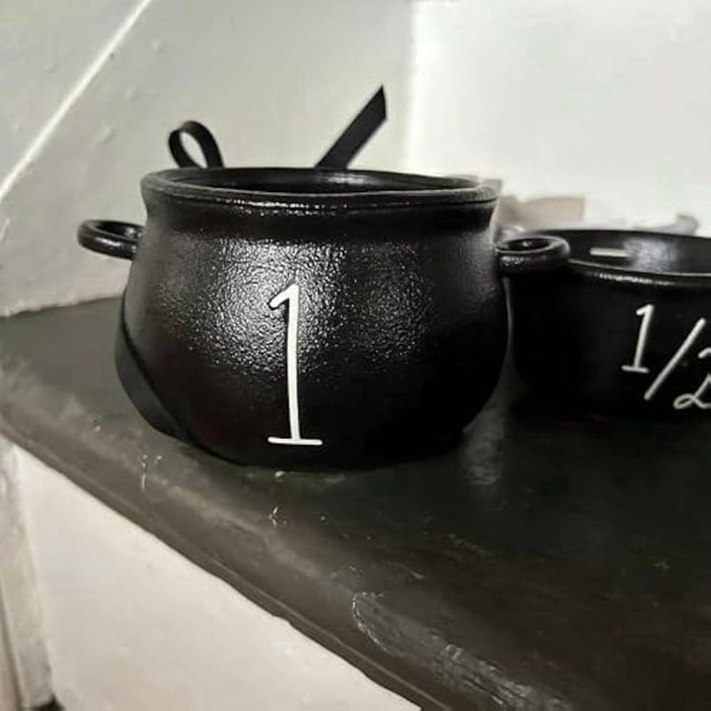 Mini witch cauldron set with four small cauldrons and measuring cups for Halloween pretend play, perfect for kids' imaginative fun.