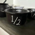 Mini witch cauldron set with four small Halloween-themed cauldrons and measuring cups for pretend play, suitable for kids' Halloween decorations.