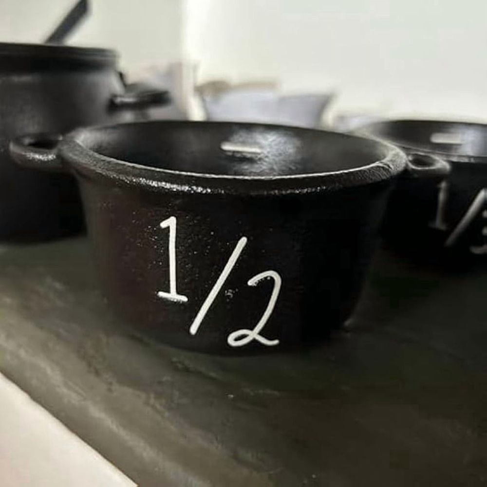 Mini witch cauldron set with four small Halloween-themed cauldrons and measuring cups for pretend play, suitable for kids' Halloween decorations.