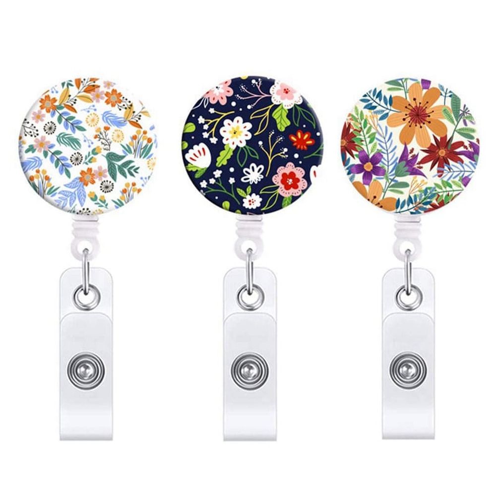 Three retractable badge reels with flower designs and alligator clips, ideal for nurses and office workers for ID badge holding.