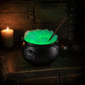 Witch cauldron decoration with skeleton figure, glowing green bubbling liquid, hanging from black tripod, weather-resistant plastic for Halloween.