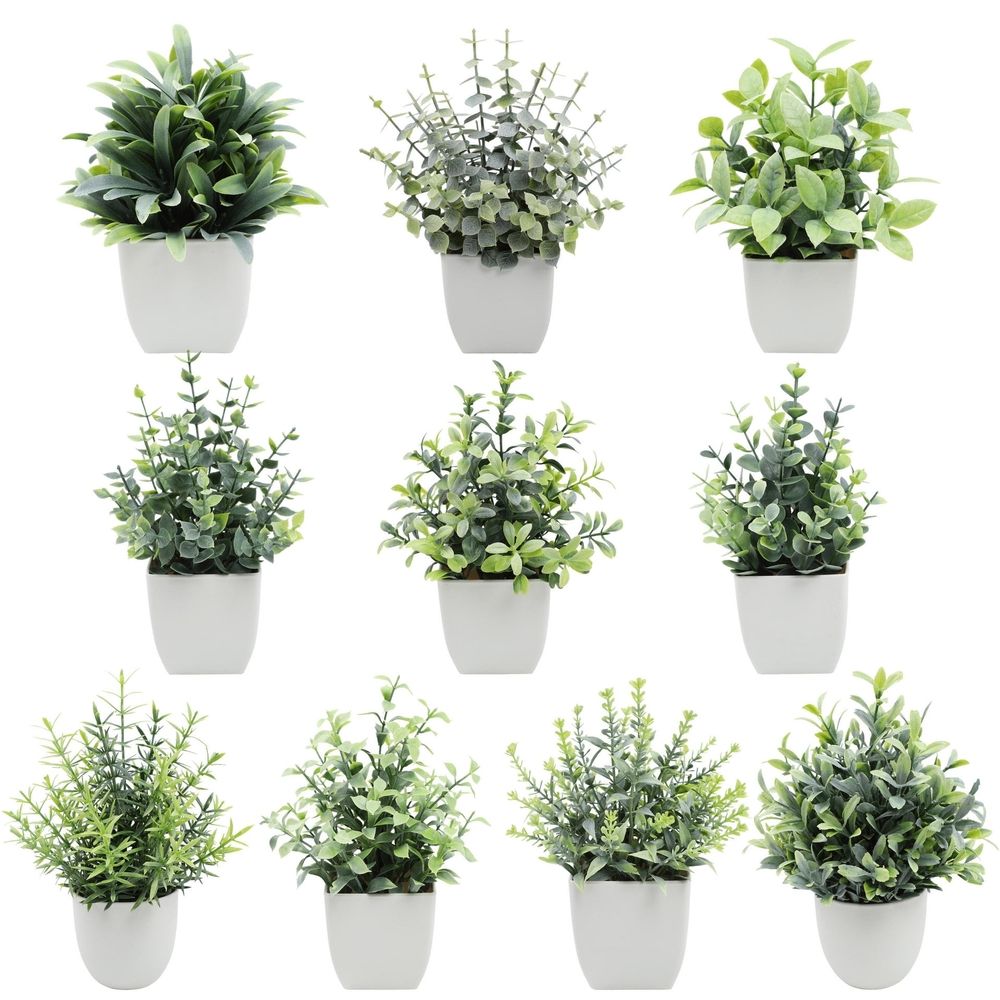 Artificial indoor plant with green leaves in a white modern planter, ideal for home or office decor.
