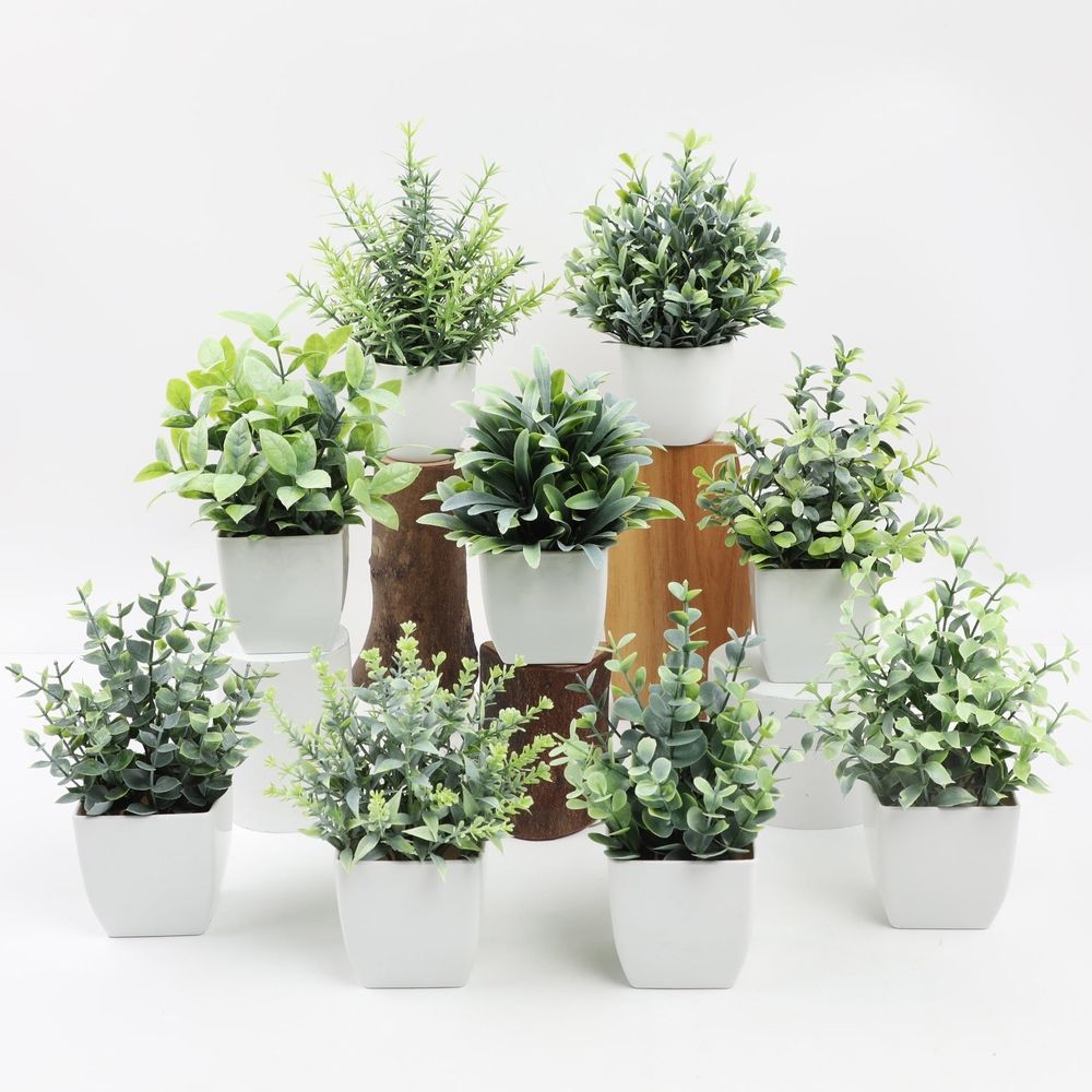 Artificial green plant in a modern white pot, ideal for indoor decor, office, or home decoration with faux leafy foliage.