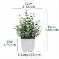 Artificial indoor plant with green leaves in a modern white pot, ideal for desk or home decoration.