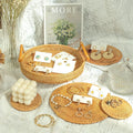 Small round rattan serving tray with wooden handle, handcrafted boho-style basket for coffee table or party decor.