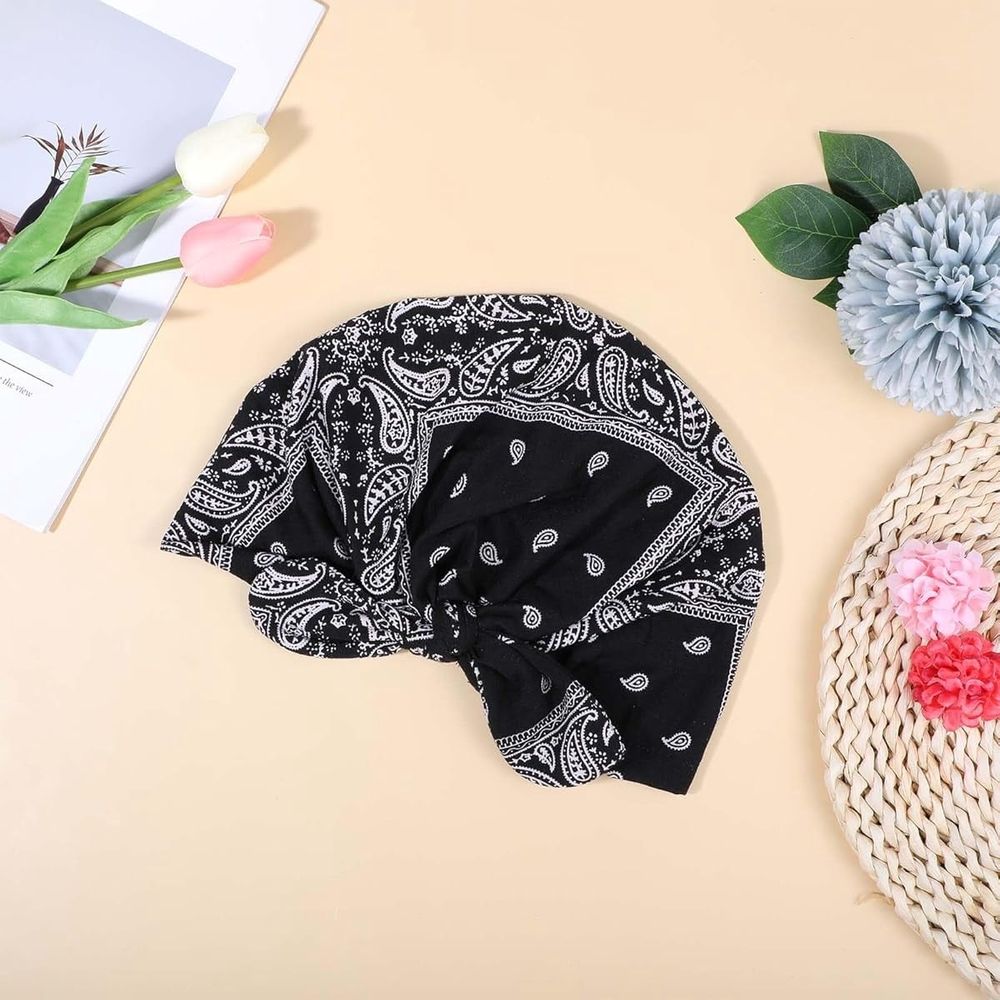 Baby girl wearing a pink beanie with a bow, turban-style headwear, suitable for sleep and casual wear by Everything Baby.