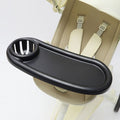 Black universal stroller snack tray with flexible silicone arm gripper for secure attachment and easy snacking on the go.