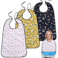 Three reusable adult bibs for elderly women and men, with crumb catchers, used as clothing protectors during feeding.