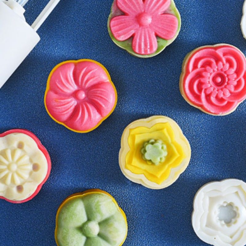 Pink Chinese flower moon cake press mold with six stamps, used for making moon cakes and pastries for holidays and parties.