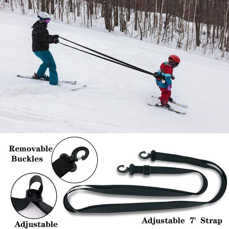 Black toddler ski training safety belt with nylon webbing and leash, designed for beginner snowboarders and kids' ski lessons.