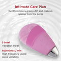 Pink facial cleansing massager brush with soft silicone bristles, waterproof and rechargeable electric handheld face massager for skincare.