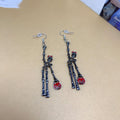 Spooky skull skeleton dangle earrings with bloody knife design for women, perfect for Halloween costumes and spooky occasions.