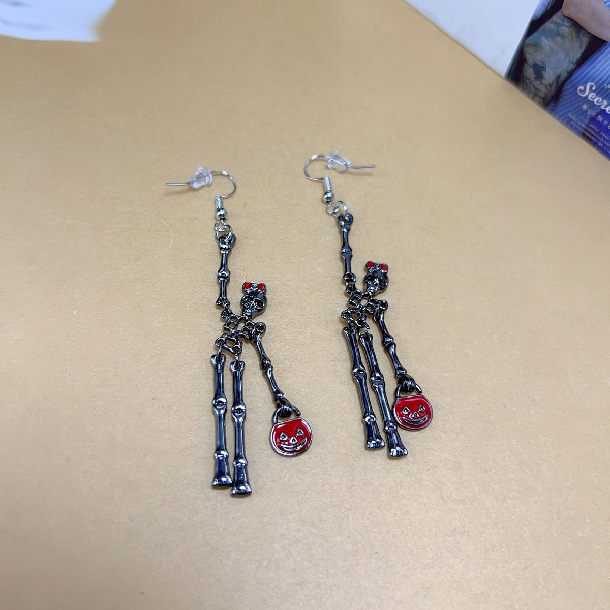Spooky skull skeleton dangle earrings with bloody knife design for women, perfect for Halloween costumes and spooky occasions.