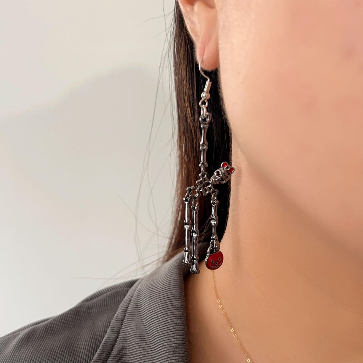 Spooky skull skeleton dangle earrings with bloody knife design for women, Halloween jewelry featuring scary, horror-themed details.