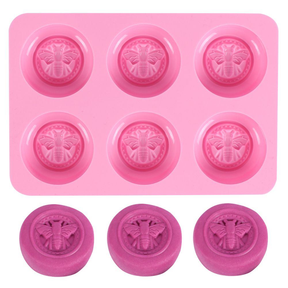 Pink round silicone mold with honeybee design for making homemade soaps, lotion bars, jello, bath bombs, or chocolates.