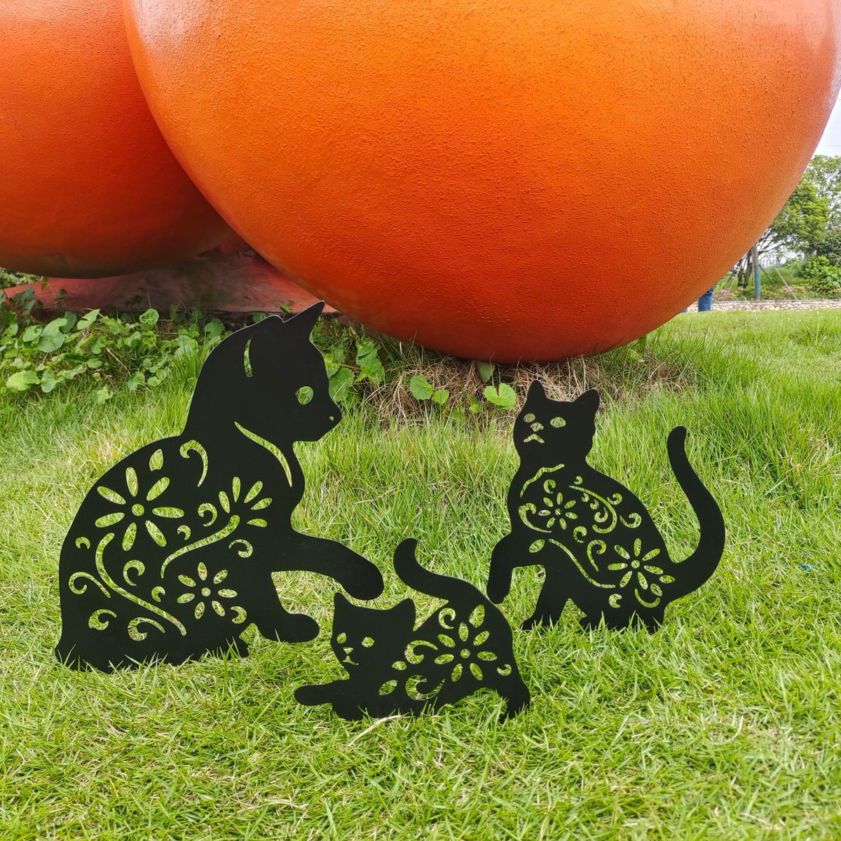 Set of three black metal garden stakes featuring playful black cat silhouettes for yard outdoor lawn patio decoration.