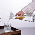 Acrylic water carafe with flip top lid, food-grade and shatterproof, used for water, iced tea, or juice, in a baby and kids feeding setting