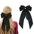 Black satin hair clips with large bow and long ribbon, ideal for girls' hair accessories and party hairstyles.