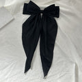 Black satin hair bow barrette with long ribbon for girls, stylish hair accessory for parties and special occasions.