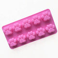 Pink silicone mold with mini dog and cat paw prints for cupcakes, ice cubes, chocolate, soap, or candles, ideal for baking and crafts.