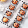 Non-stick 8-cavity cake baking pan with panda and bear molds, ideal for muffins, brownies, and cheesecakes, by Everything Baby