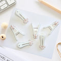 Set of 12 grey plastic clothespins with cute cat paw pattern, strong grip for laundry, snack, or food bag clips.
