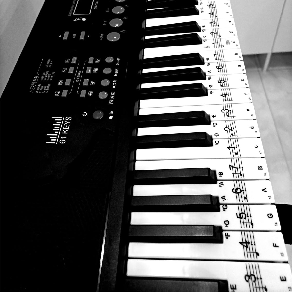 Transparent piano keyboard stickers by Everything Baby on a child's toy piano, easy to remove and perfect for kids learning piano.