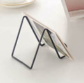 Metal square wire cutting board stand for holding cheese boards, platters, or cookbooks, ideal for kitchen or serving display.