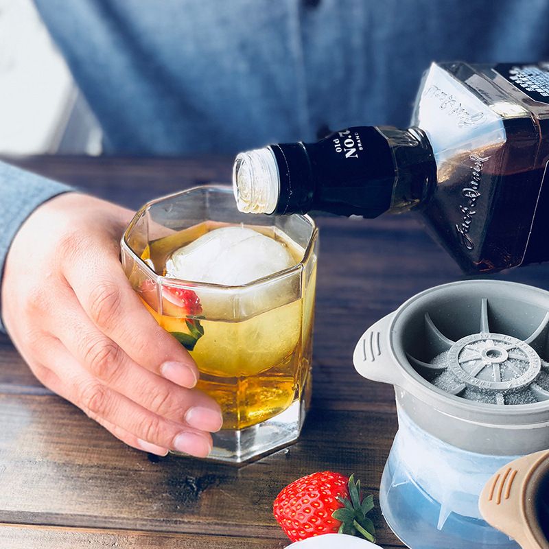 Blue and grey giant silicone ice cube molds tray with two round whiskey ice ball makers for drinks.