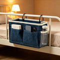 Canvas bedside caddy hanging organizer with water bottle holder, ideal for dorm bunk beds and kids' bedrooms.