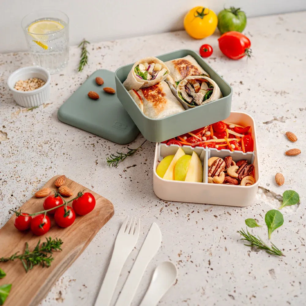 Green Monbento Flex kid's lunch box with two compartments and cutlery, featuring a natural design for children.