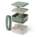Green Monbento Flex kid's lunch box with two compartments and cutlery, designed for children, featuring a durable, eco-friendly design.