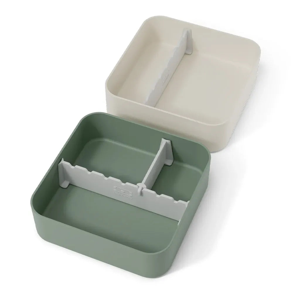 Green Monbento Flex kid's lunch box with two compartments and cutlery, designed for children's lunch storage.